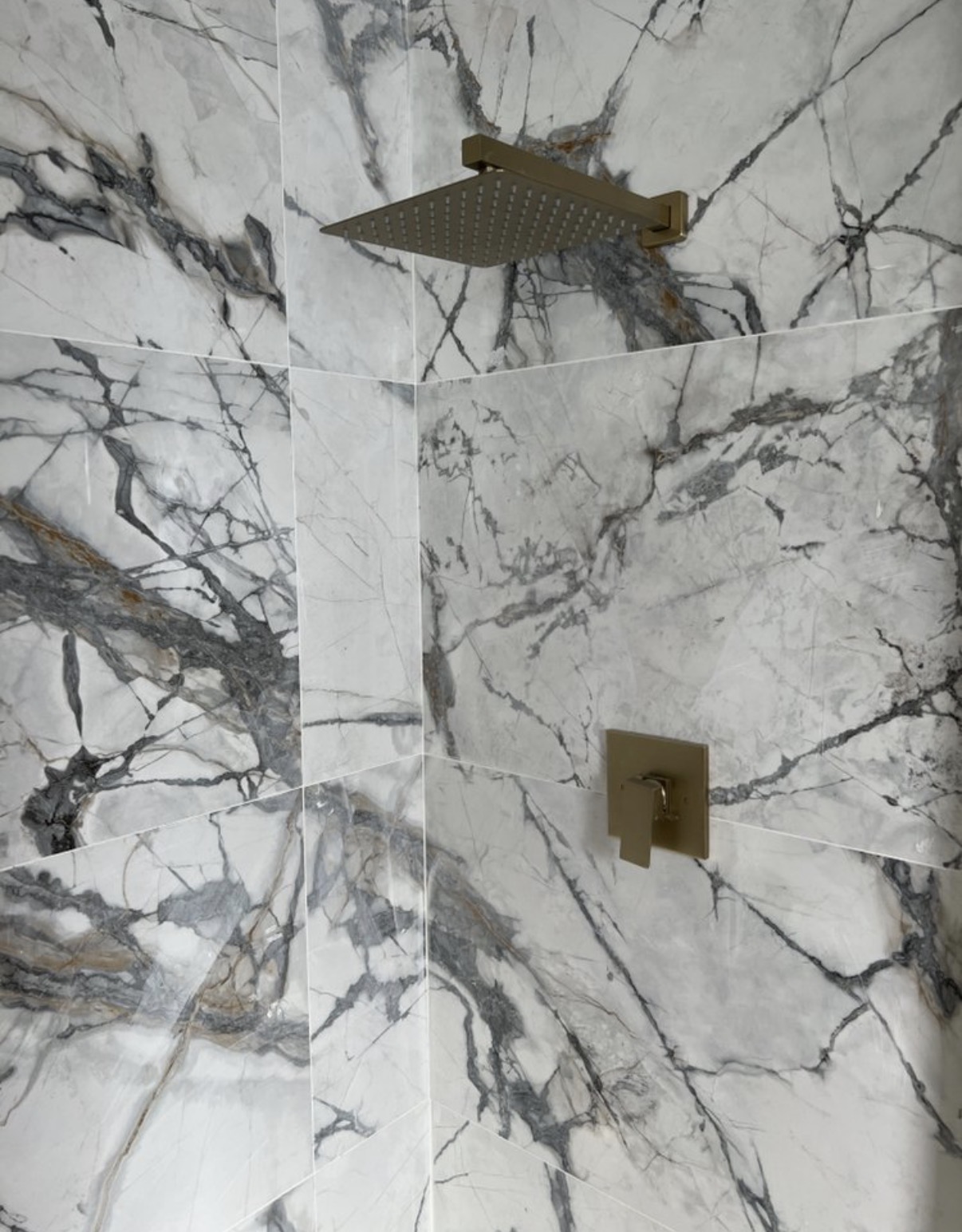 Marble shower wall close-up with brass fixtures
