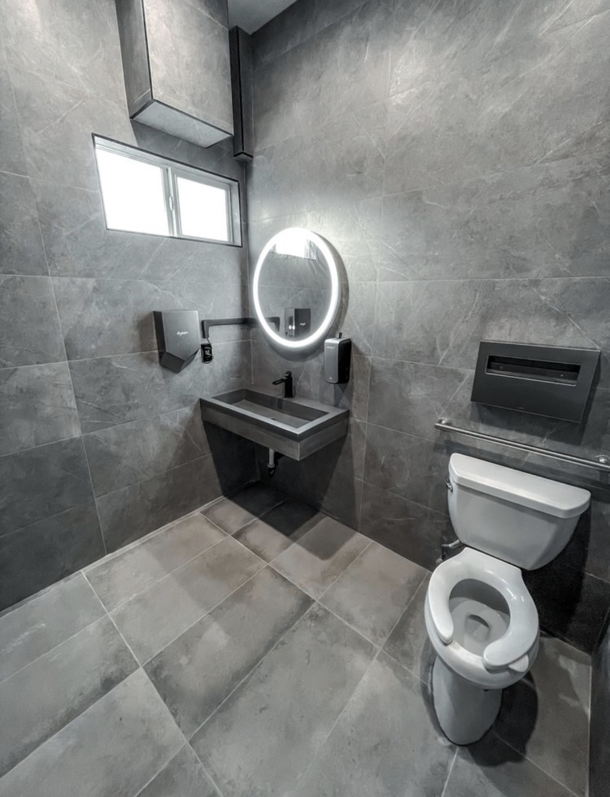 Modern grey-tile bathroom with LED mirror