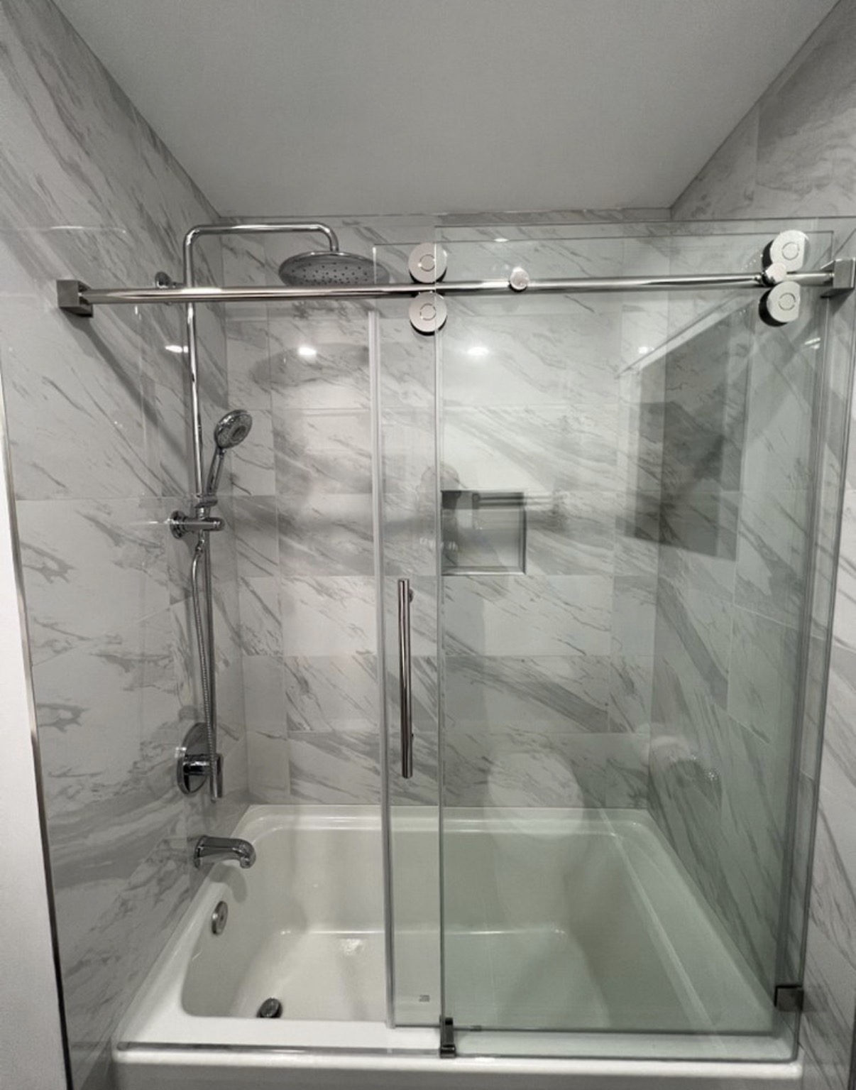 Marble tub-shower with frameless glass